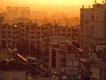 High angle view of buildings in city at sunset
