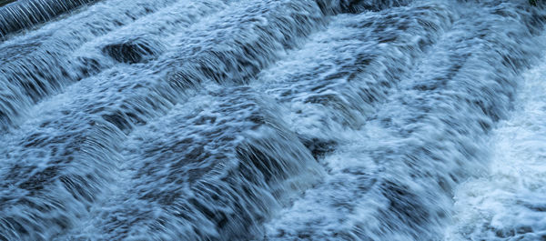 View of water at long exposure to get smooth blurred water effects white water waves over river weir