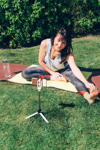 Full length of young woman sitting on field