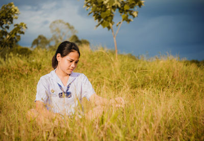 Full length of girl sitting on field