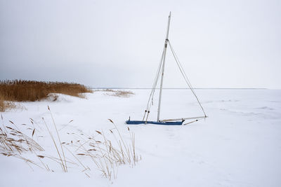 Scenic view of snow covered field against sky