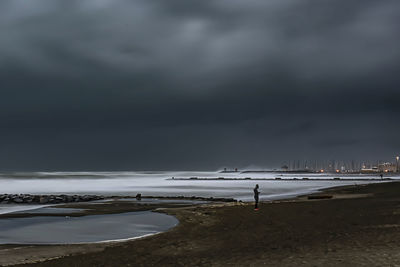 Scenic view of beach against storm clouds