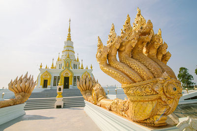 Statue of temple against building and sky