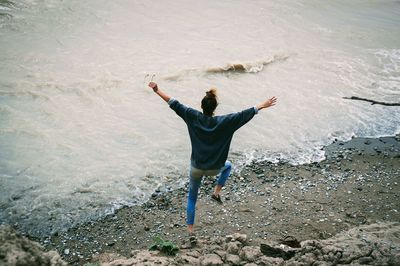 High angle view of woman jumping on shore at beach