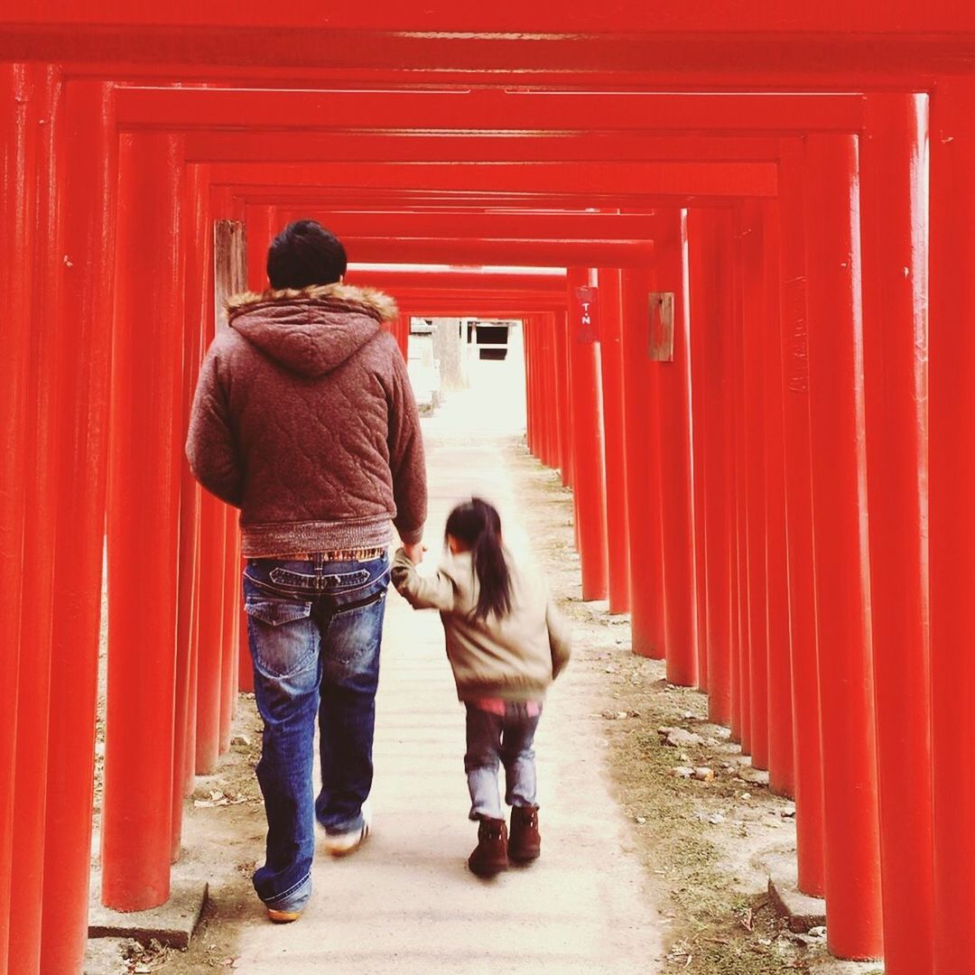 FULL LENGTH REAR VIEW OF COUPLE WALKING ON RED ROAD