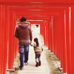 Rear view of couple walking on red road