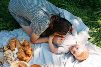 Family mom and son on picnic. smiling and enjoying summer on blanket in park.