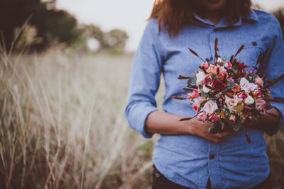 Midsection of woman holding flower bouquet