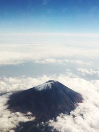 High angle shot of rocky peak against clouds