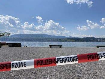 Information sign on beach against sky