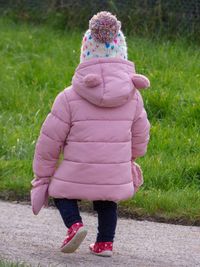 Rear view of girl standing on grass