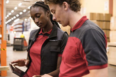 Male and female sales staff using digital tablet at hardware store