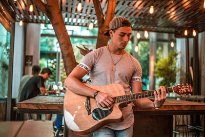 Young man playing guitar in cafe