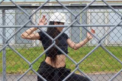 Woman seen through chainlink fence