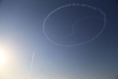 Low angle view of vapor trail against clear blue sky