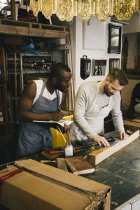 Multiracial male entrepreneurs working at upcycling workshop
