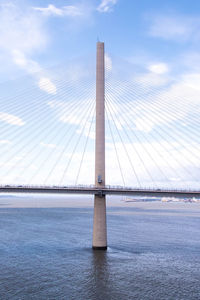 View of bridge over sea against cloudy sky