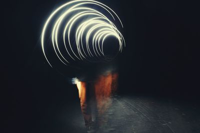 Close-up of spiral light over black background