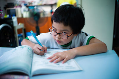 Boy looking at book on table