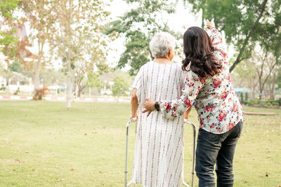 Rear view of women standing by plants