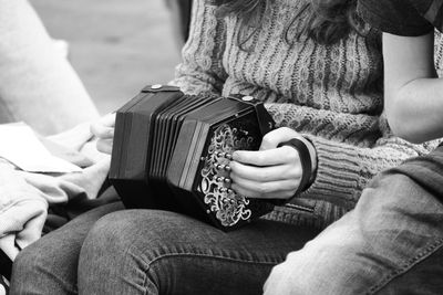 Midsection of woman playing musical instrument