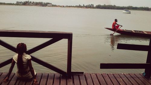 Rear view of people sitting on sea shore