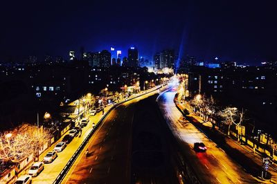 Illuminated cityscape against sky at night