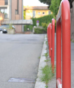 Close-up of red railing on footpath in city