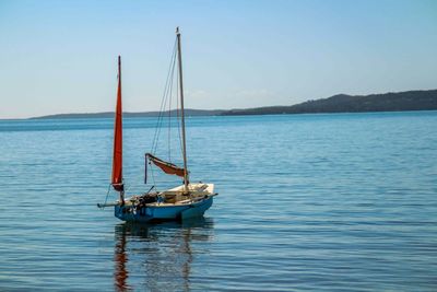 Boat sailing in sea against clear sky