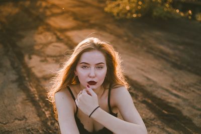 Portrait of beautiful young woman standing against blurred background