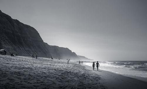 People on beach against sky