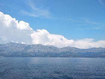 Scenic view of sea by mountains against sky