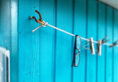 Close-up of rusty metal fence against blue door