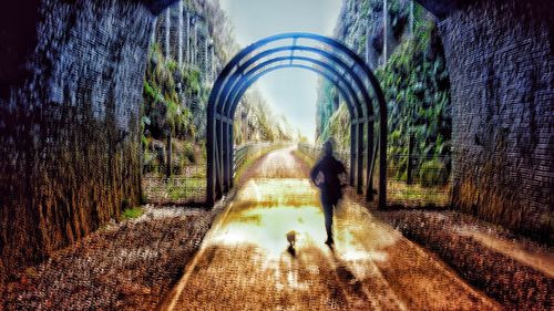 Rear view of people walking in tunnel