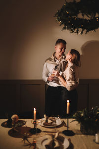 A man and a woman in love at a romantic dinner give each other gifts for christmas in the evening