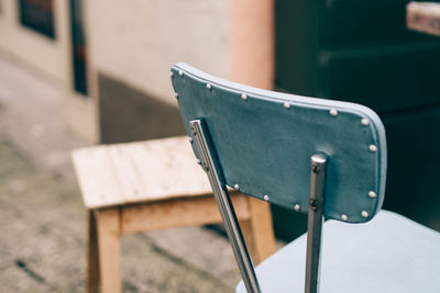 Close-up of empty bench against wall