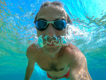 Portrait of shirtless man swimming in sea