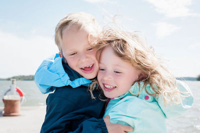 Portrait of brother and sister laughing at the beach together