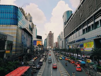 Vehicles on road in city against sky