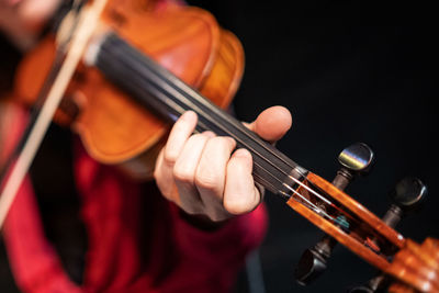 Midsection of man playing guitar at music concert