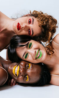 Portrait of women lying against white background