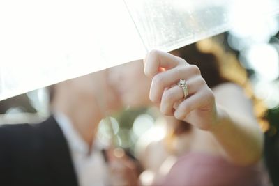 Close-up of couple kissing under umbrella