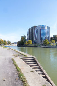 River by buildings against clear blue sky