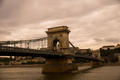 View of bridge over river against cloudy sky