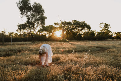 Rear view of man on field against sky