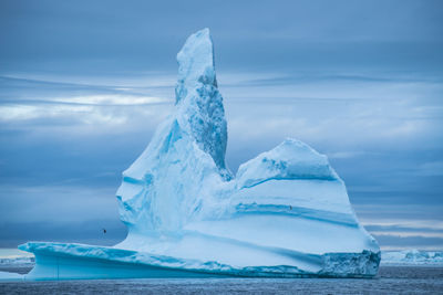 View of ice berg in sea against sky