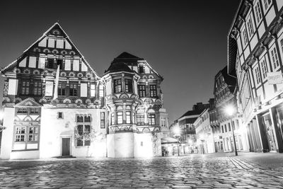 Illuminated buildings against clear sky at night