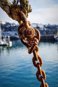 Close-up of rusty chain against sky