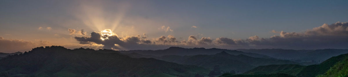 Panoramic view of silhouette mountains against sky during sunset