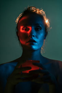 Close-up of young woman against blue background